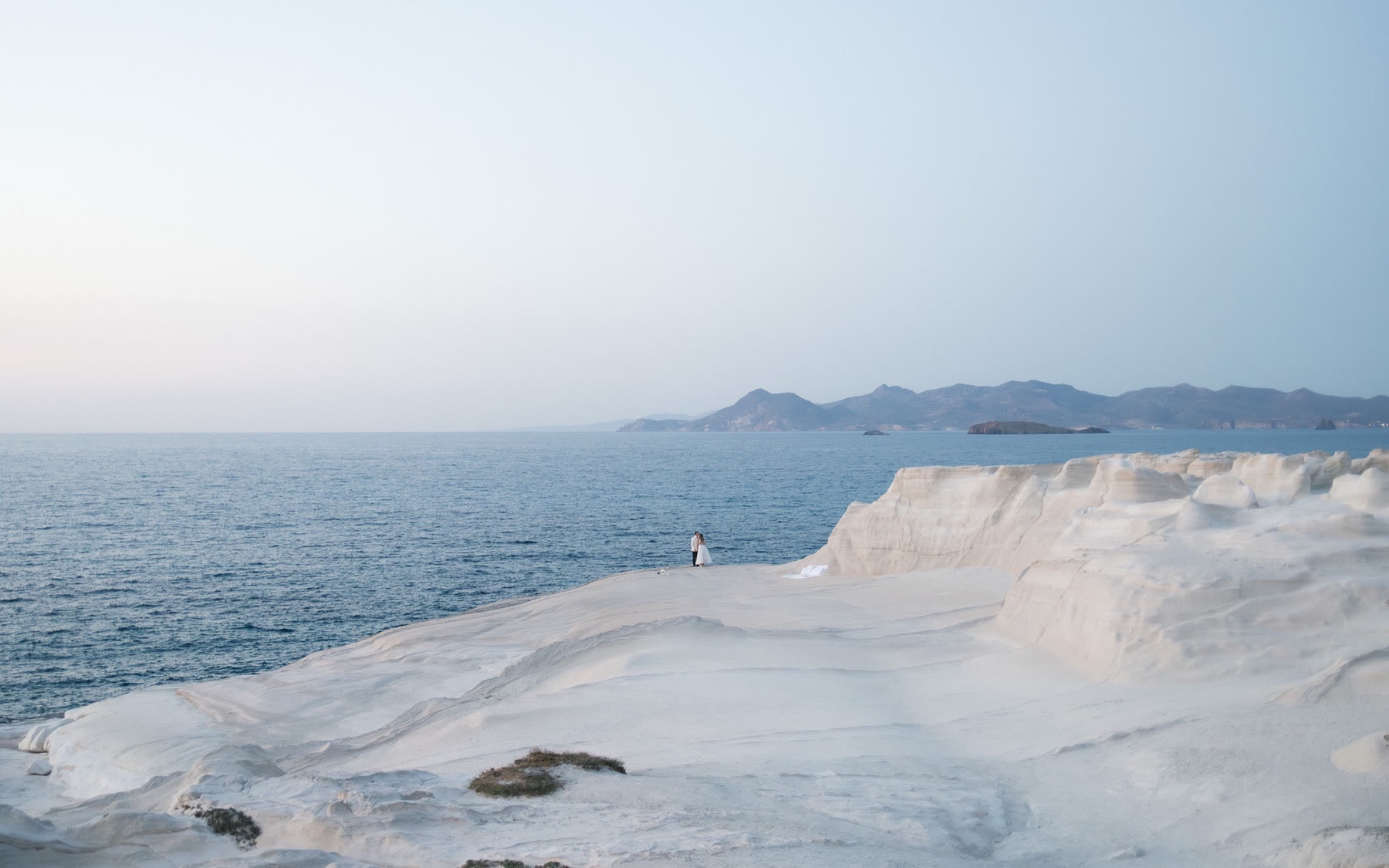 Bride and groom finish their elopement at a room by the sea in Milos, Greece